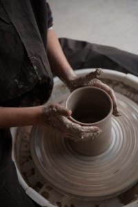 Ceramista profesional esculpiendo una forma en un torno de alfarero en Clay Cave