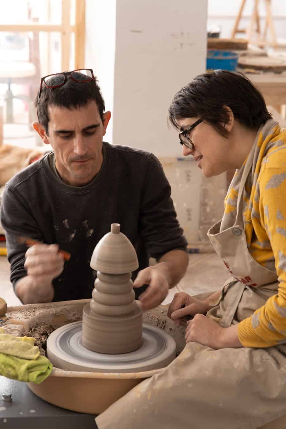 Two ceramic artists collaborating on a pottery piece in ClayCave’s coworking ceramics studio, Valencia.